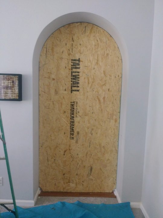 Before: Arched doorway boarded up, then plastered to a finished arch
