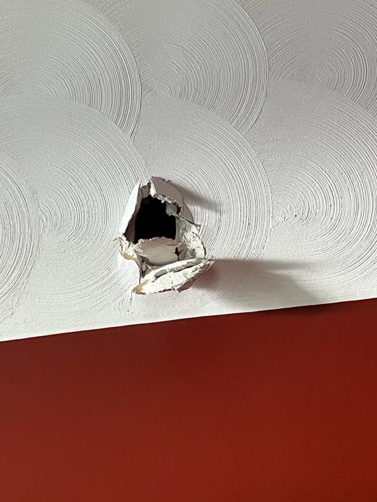 Before: Hole through a swirl ceiling, patched and the swirl matched so it disappears