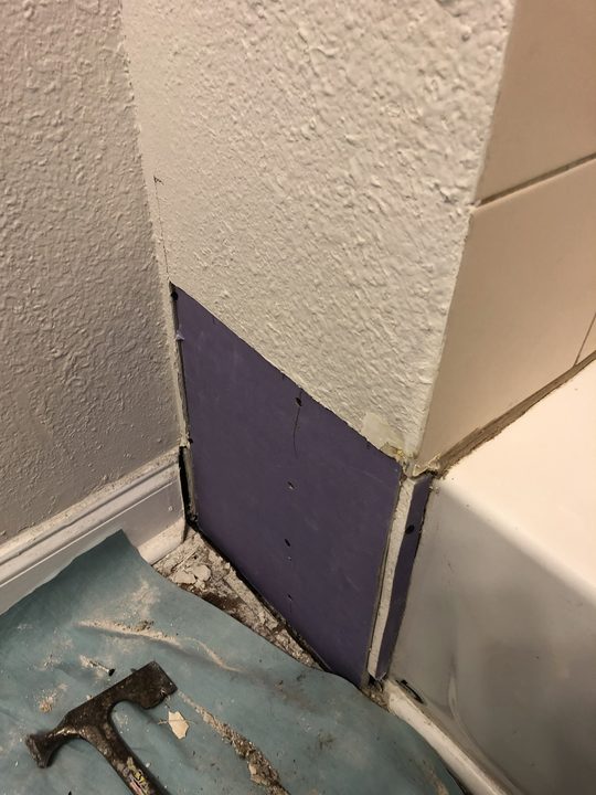 Before: Textured wall torn out at the base, repaired and texture matched